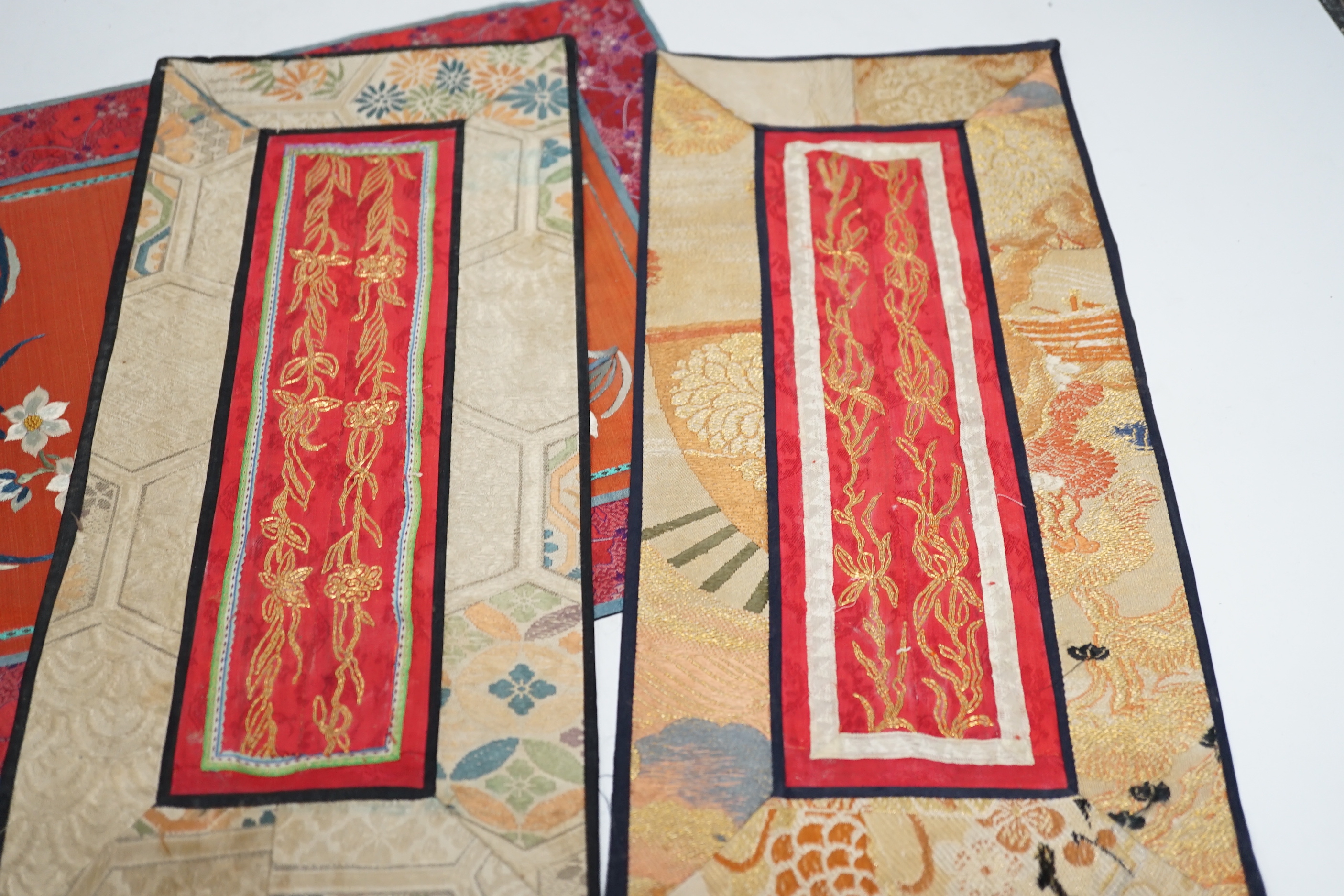 Nine Chinese silk embroidered panels, embroidered with gold thread and bordered with silk damask and brocade